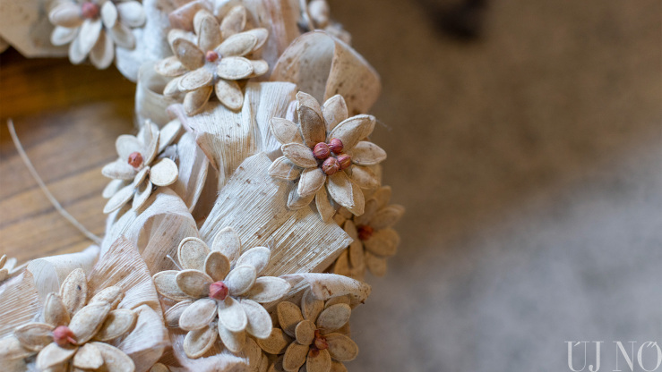 Kukoricahéjból (csuhéból) készült koszorú tökmagvirágokkal, közepükön piros kukoricaszemek Kukoricahéjból (csuhéból) készült koszorú tökmagvirágokkal, közepükön piros kukoricaszemek